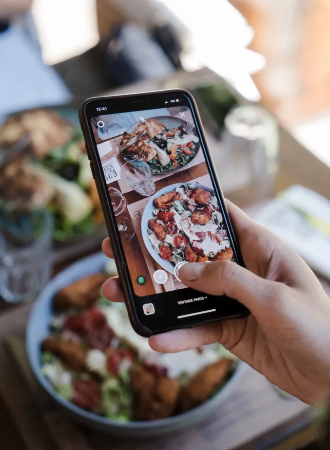 Photo d'un téléphone en train de prendre en photo ses plats
